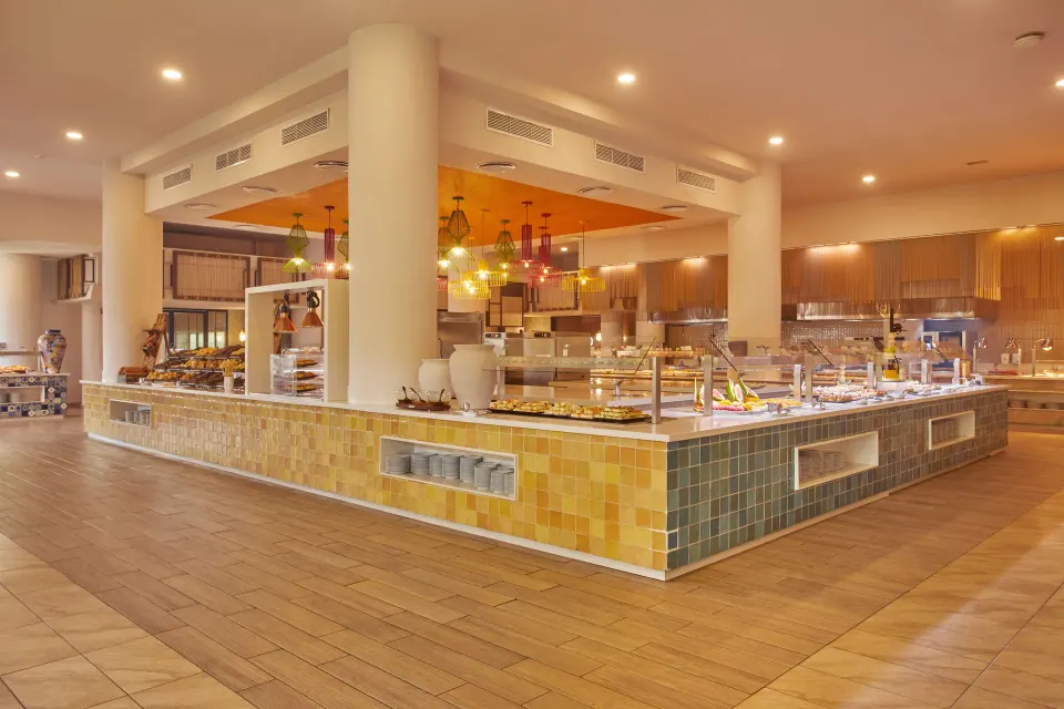 Self-serve buffet island with tiled counters in bright dining area at Bahia Principe Grand Tulum
