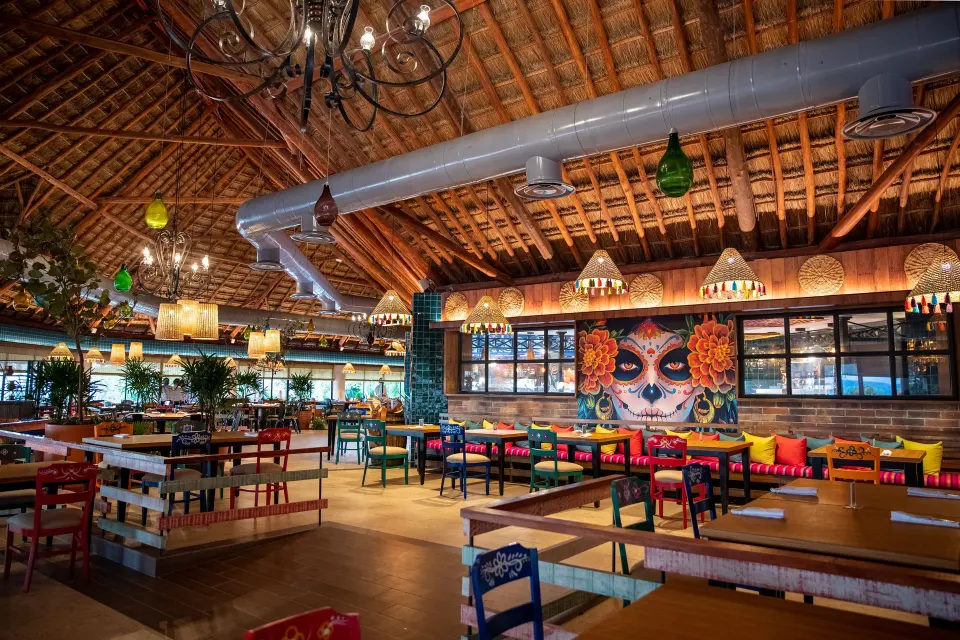 Colorful casual restaurant interior with Mexican-inspired mural at Bahia Principe Grand Tulum