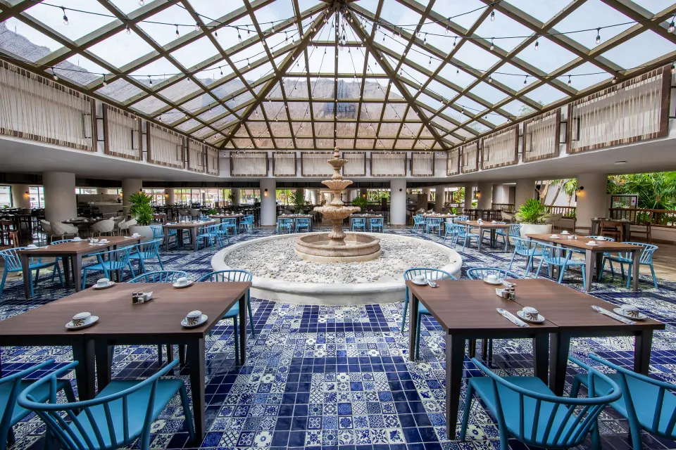 Bright dining room with central fountain and tiled floor at Bahia Principe Grand Tulum