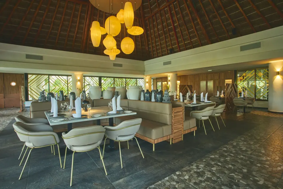 Elegant indoor restaurant with booth seating and pendant lights at Bahia Principe Grand Tulum