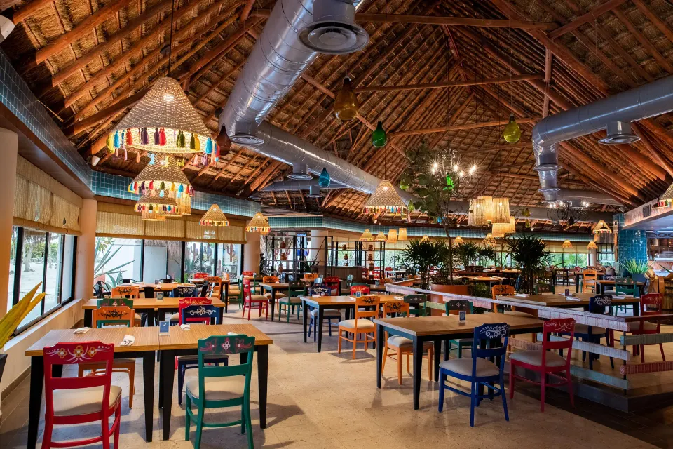 Wide view of colorful family-style restaurant seating at Bahia Principe Grand Tulum
