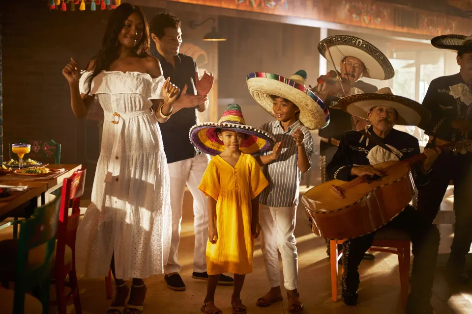 Family enjoying live mariachi-style performance inside Bahia Principe Grand Tulum restaurant