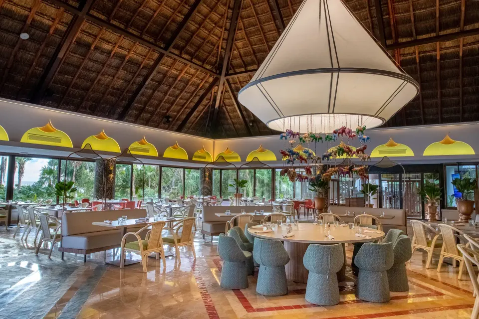 Airy round dining room with large central pendant and palm views at Bahia Principe Grand Tulum