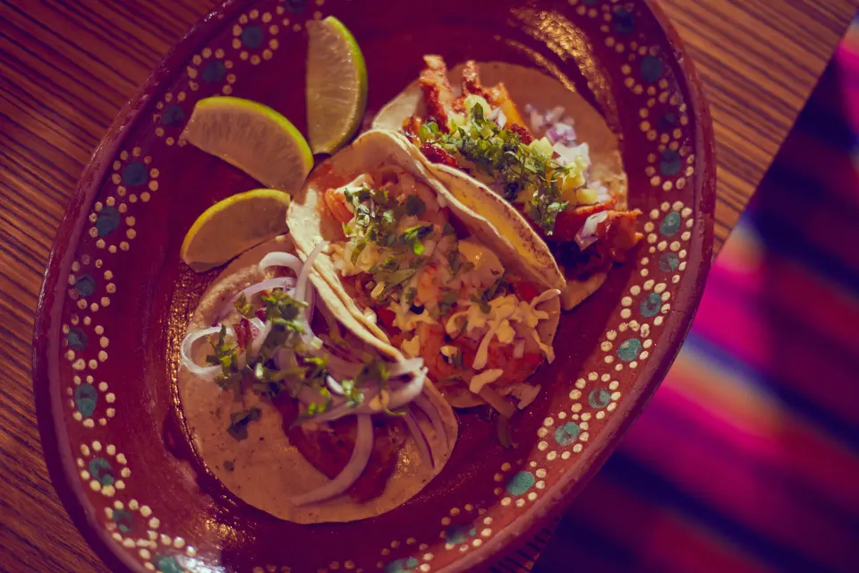 Three tacos on a decorative plate at Bahia Principe Grand Tulum