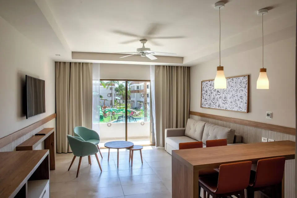 Family Suite interior with dining counter, seating and terrace at Bahia Principe Grand Tulum