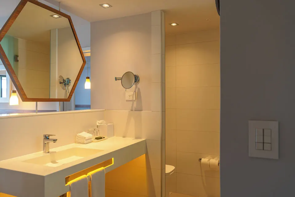 Bathroom sink, mirror and toilet area of a Junior Suite at Bahia Principe Grand Tulum
