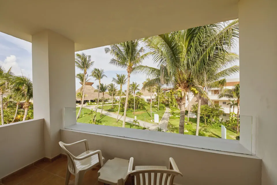 Balcony view from junior suite overlooking palm trees and grounds at Bahia Principe Grand Tulum