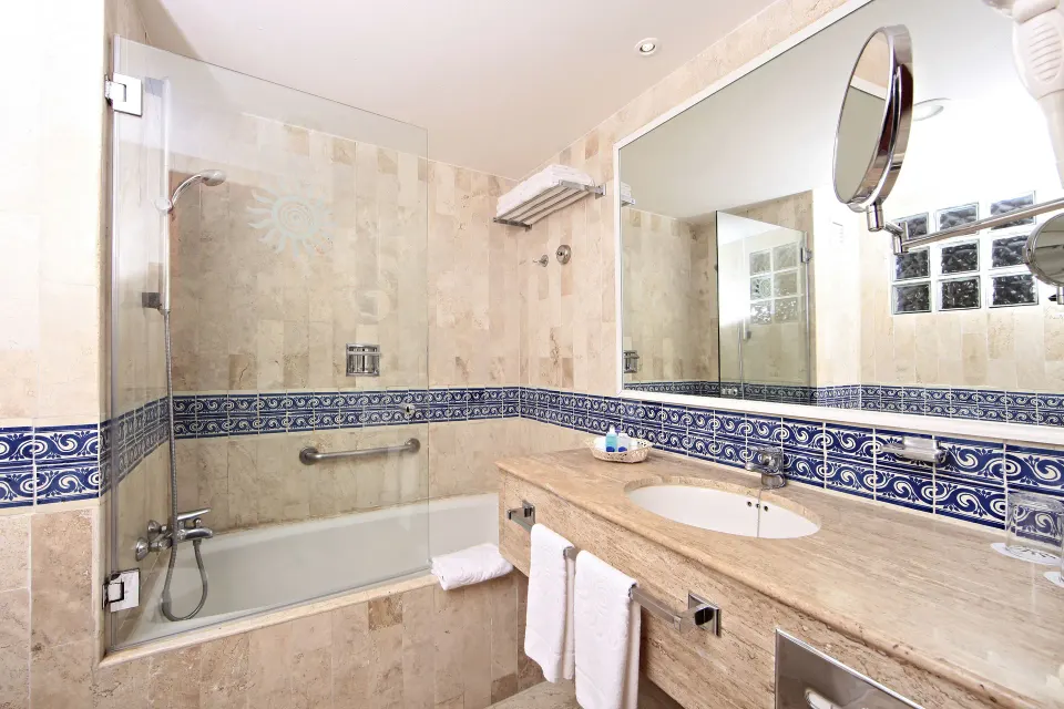 Bathroom in junior suite with tub-shower, sink and large mirror at Bahia Principe Grand Tulum