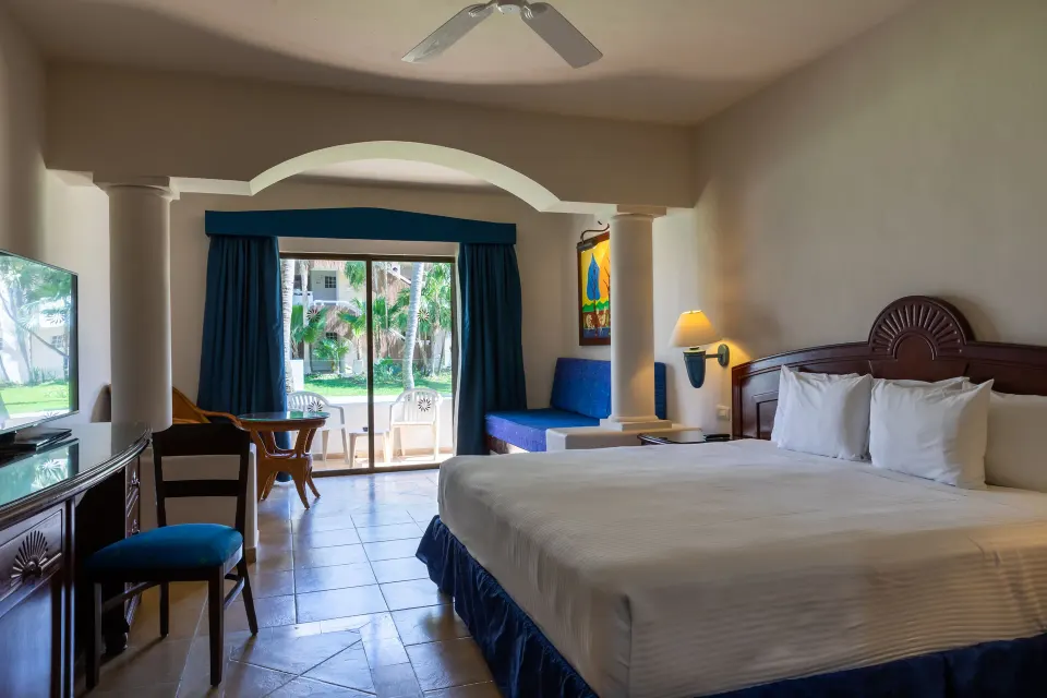 Junior Suite king bed with balcony overlooking gardens at Bahia Principe Grand Tulum