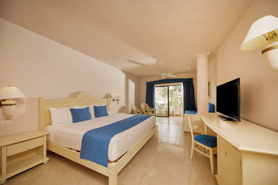 Junior Suite king bed and long dresser with TV at Bahia Principe Grand Tulum