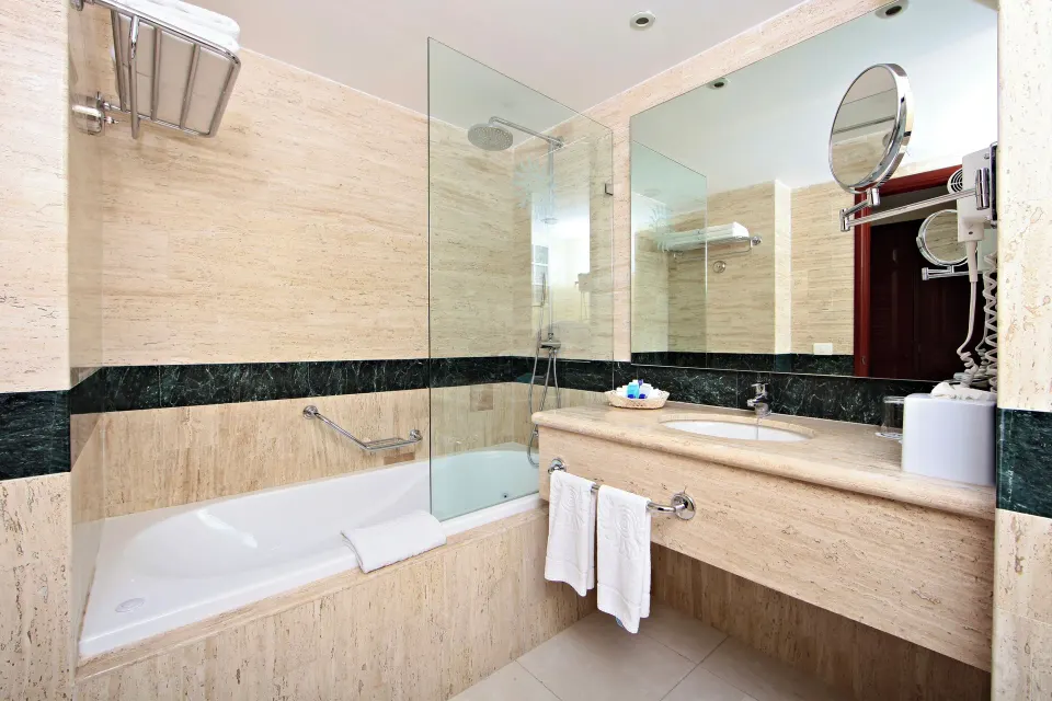 Vanity and bathtub with glass divider in a Junior Suite bathroom at Bahia Principe Grand Tulum