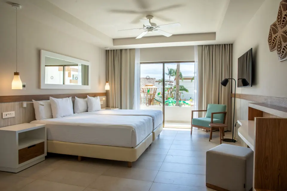 Bright Premium Oceanfront room with king bed, lounge chair and balcony at Bahia Principe Grand Tulum