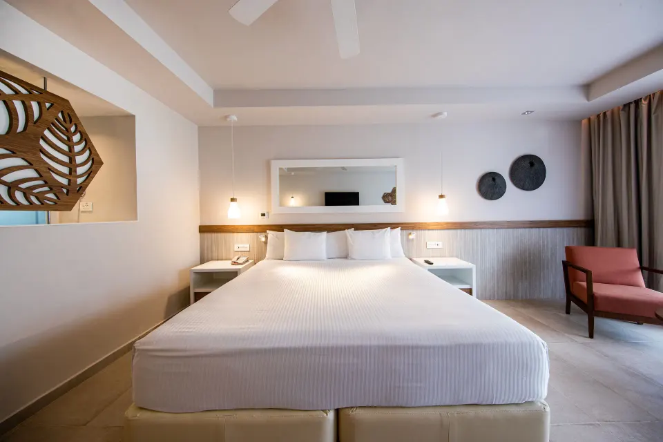 Premium Room (Superior 2+2) front view of king bed and bedside lights at Bahia Principe Grand Tulum