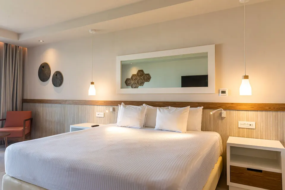 King bed in Premium Room with bedside lights and large mirror at Bahia Principe Grand Tulum