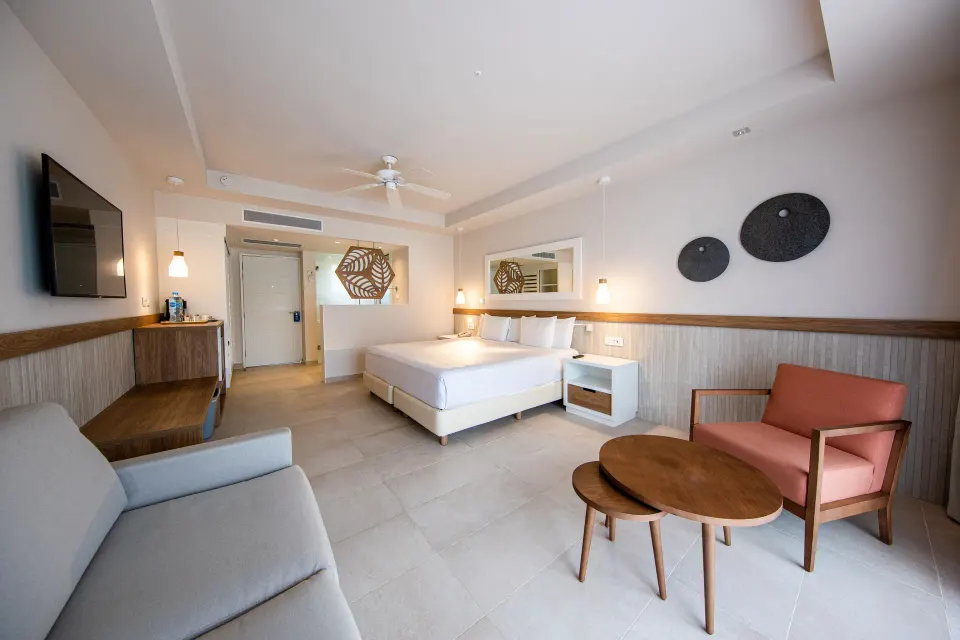 Spacious Premium Room (Superior 2+2) with seating area and armchair at Bahia Principe Grand Tulum