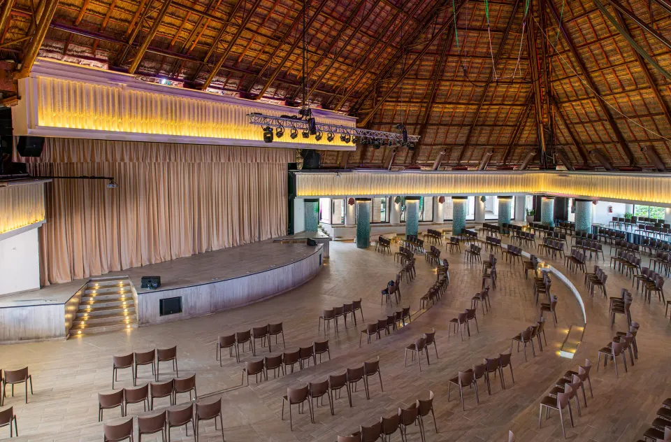 View from above of curved seating and stage in the resort's palapa at Bahia Principe Grand Tulum