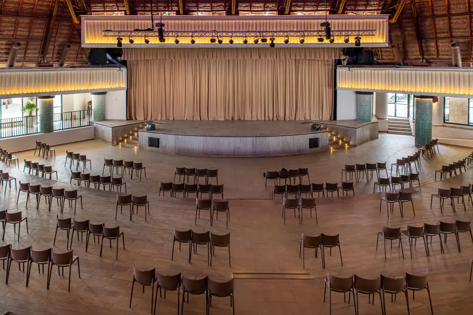 Large event auditorium with stage and rows of chairs at Bahia Principe Grand Tulum