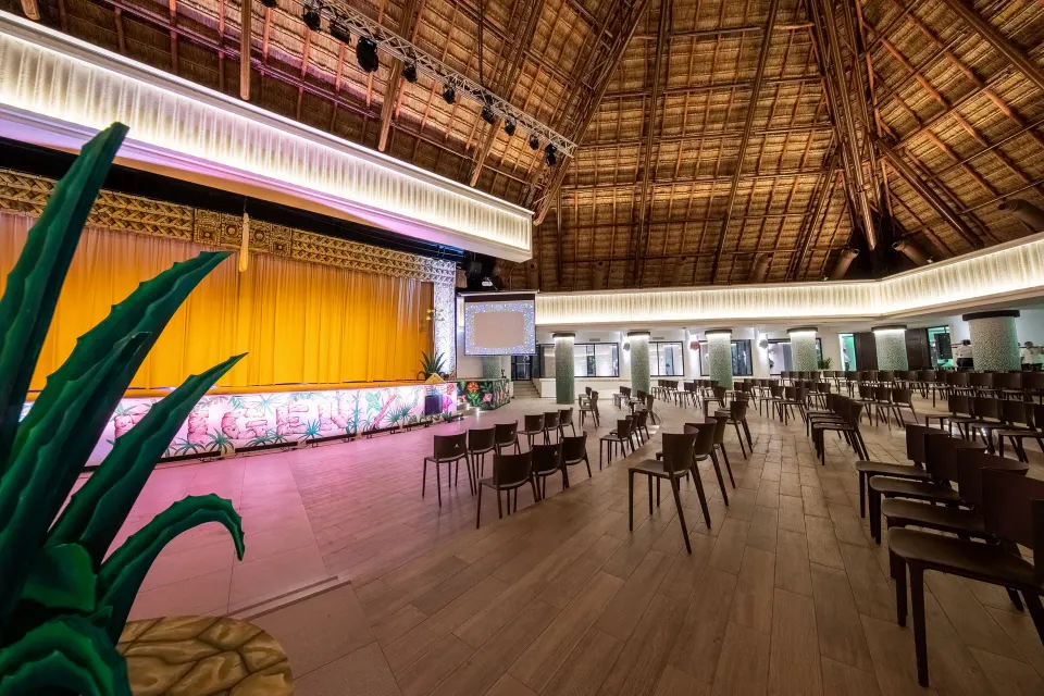 Wide interior of palapa performance venue with empty chairs at Bahia Principe Grand Tulum