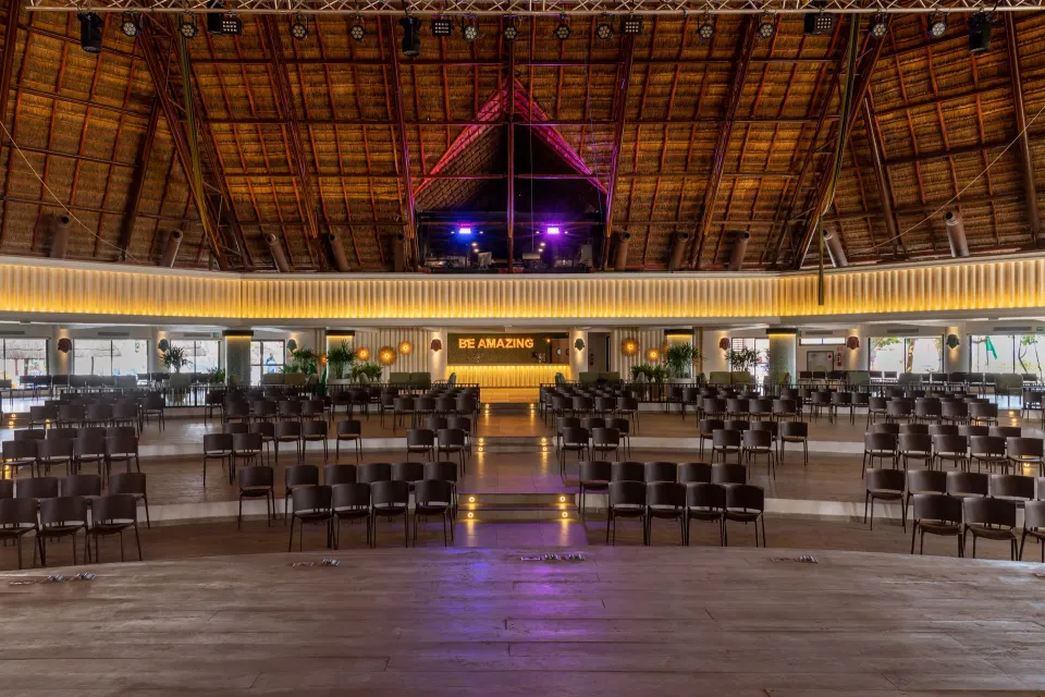 Stage view looking out across chairs and a lit sign at Bahia Principe Grand Tulum