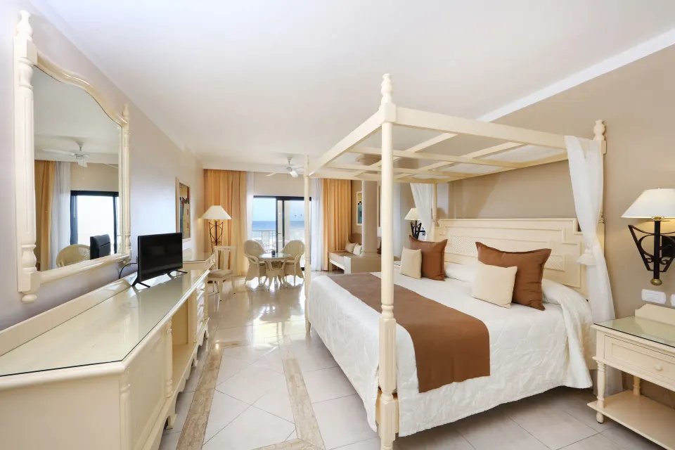 Bright suite with canopy king bed and balcony view at Bahia Principe Luxury Akumal