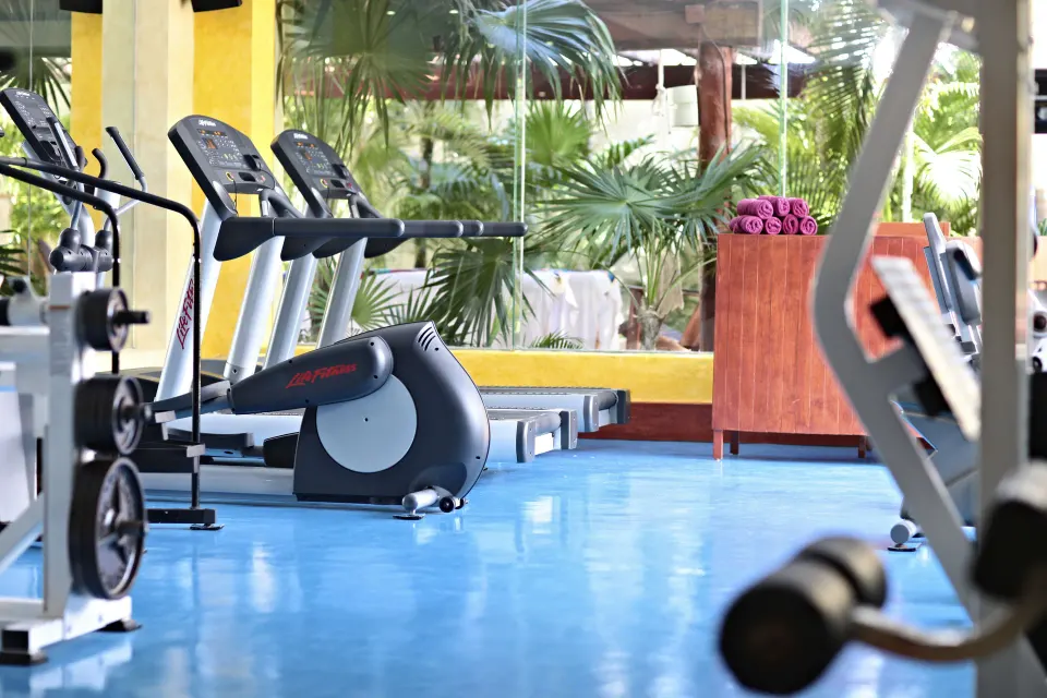 Fitness equipment and treadmills in a bright exercise area at Bahia Principe Luxury Akumal.