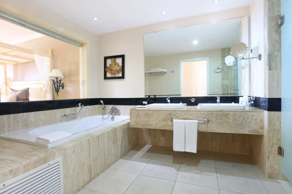 Large bathroom with bathtub, double sinks and oversized mirror at Bahia Principe Luxury Akumal