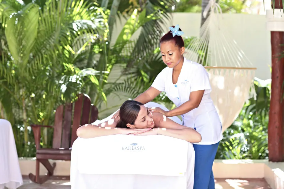 Therapist giving an outdoor massage on a table at Bahia Principe Luxury Akumal