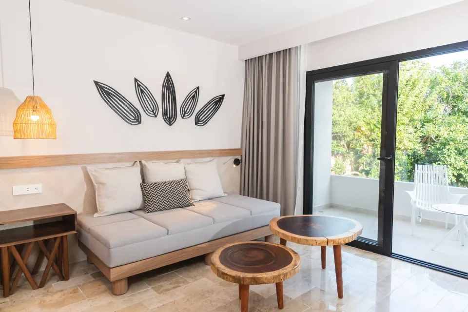 Sofa and balcony doors in a junior suite at Bahia Principe Luxury Akumal