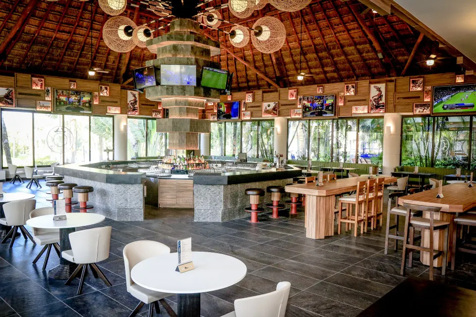 Central round bar under a palapa roof with stools at Bahia Principe Luxury Akumal