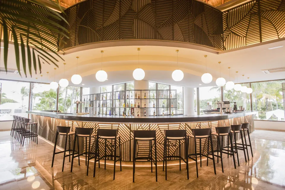 Large circular resort bar with high stools and illuminated counter at Bahia Principe Luxury Akumal