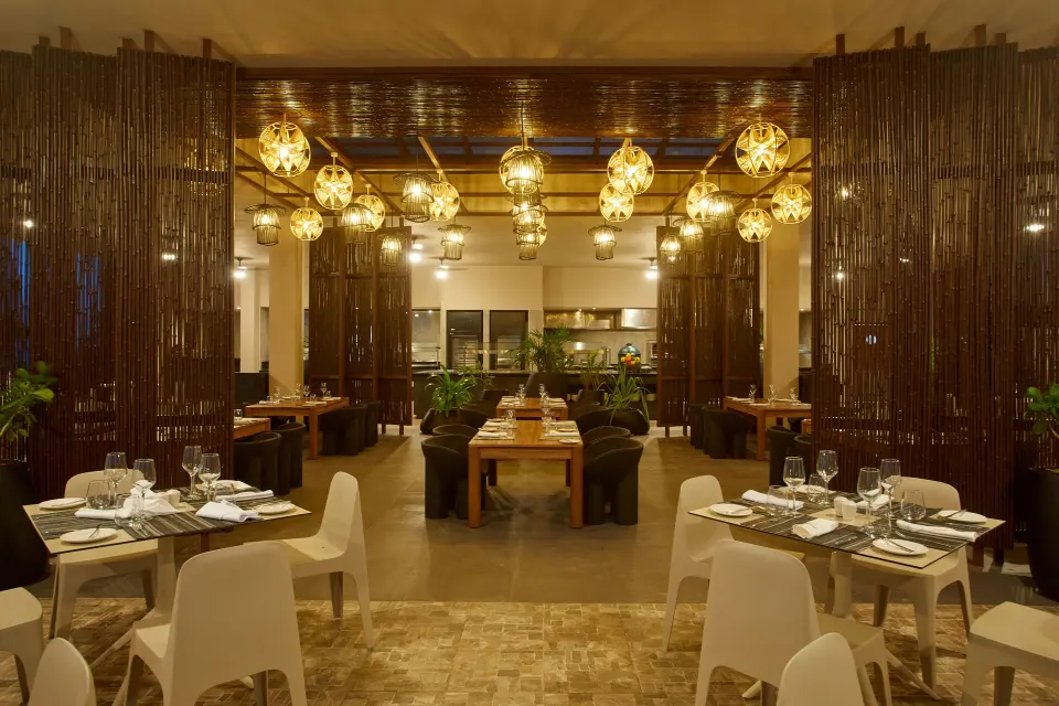 Evening view of the resort dining room with glowing lanterns at Bahia Principe Luxury Akumal
