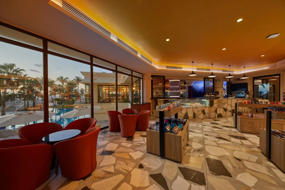 Indoor bar area with red lounge chairs and pool view at Bahia Principe Luxury Akumal