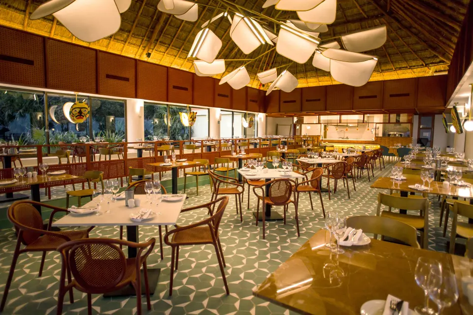 Open-air restaurant dining room with vaulted palapa ceiling at Bahia Principe Luxury Akumal