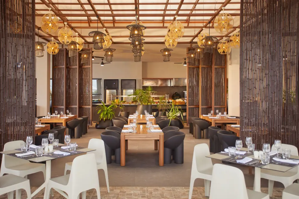 Open-air dining room with wooden screens and pendant lights at Bahia Principe Luxury Akumal