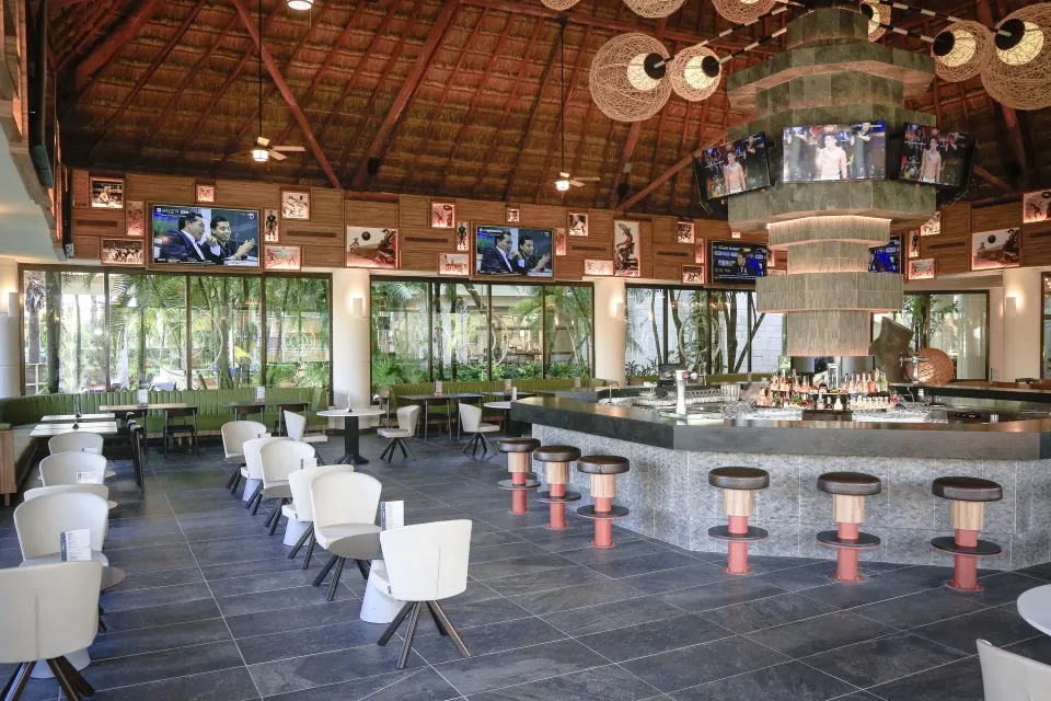 Open bar and seating under a thatched roof at Bahia Principe Luxury Akumal