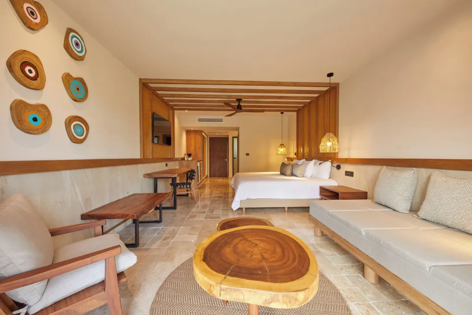 Spacious Family Suite room with king bed and wood-accented seating at Bahia Principe Luxury Akumal