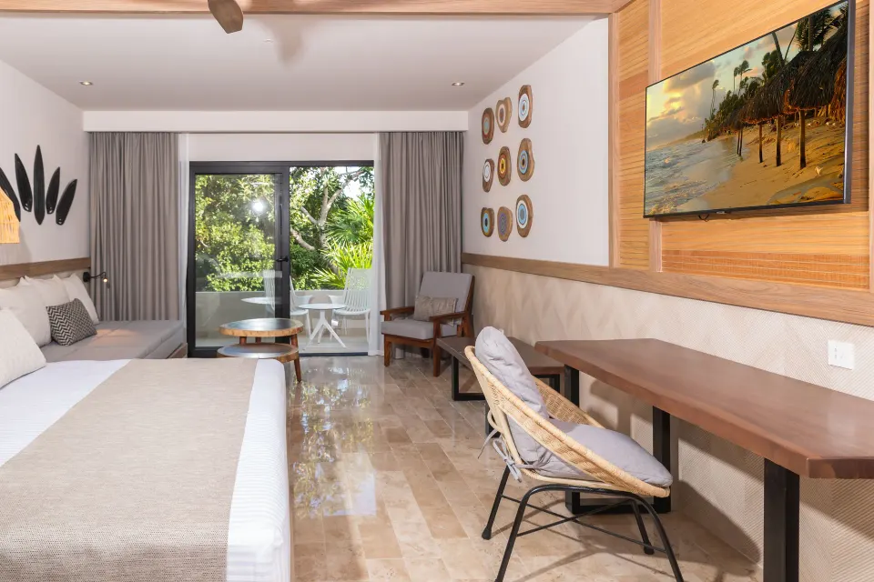 Junior Room Deluxe Swim Up interior with king bed and sliding doors at Bahia Principe Luxury Akumal