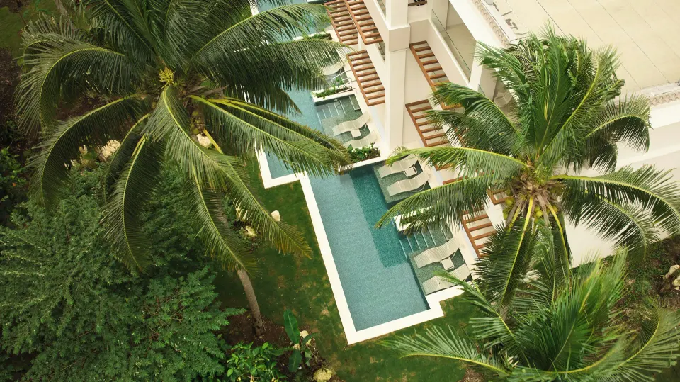 Aerial view of resort pool and surrounding palms at Bahia Principe Luxury Akumal
