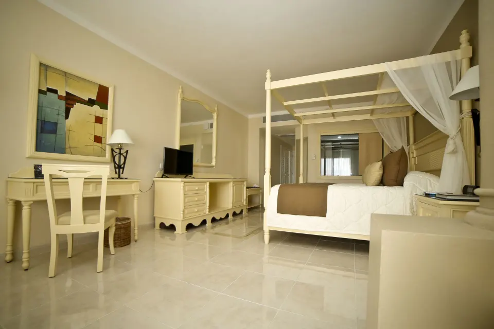 Side view of Junior Room (Deluxe) showing bed, TV and desk at Bahia Principe Luxury Akumal