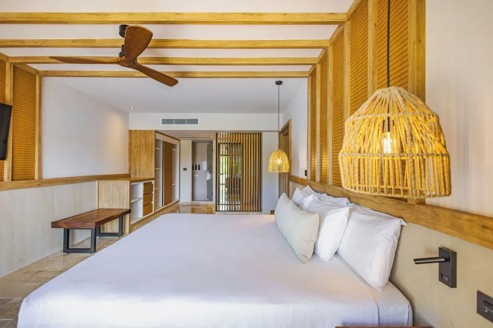 Junior Suite 1 King Bed close-up with rattan pendant light at Bahia Principe Luxury Akumal
