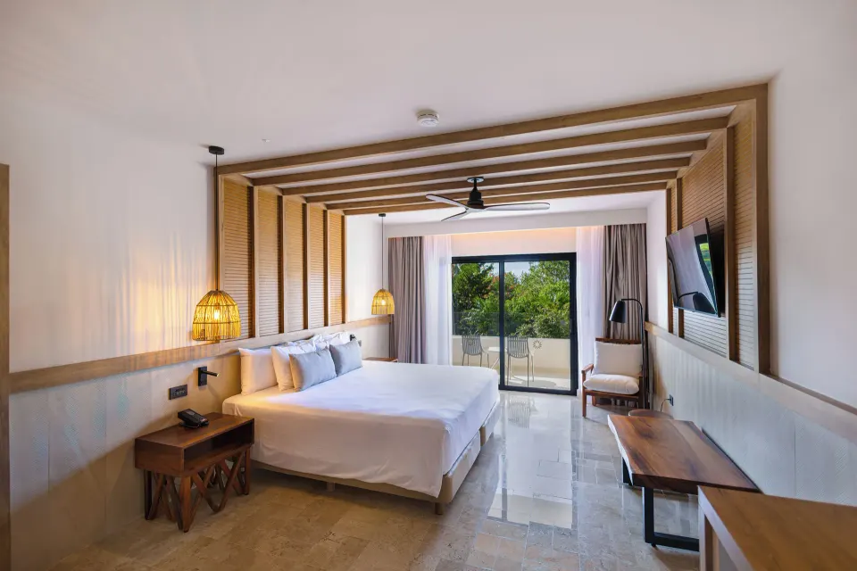 Junior Suite 1 King Bed with balcony and greenery at Bahia Principe Luxury Akumal