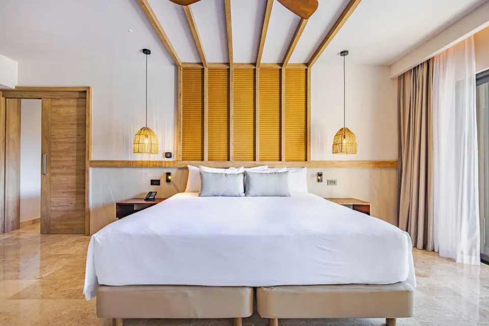 King bed and bedside lighting in a Junior Suite at Bahia Principe Luxury Akumal