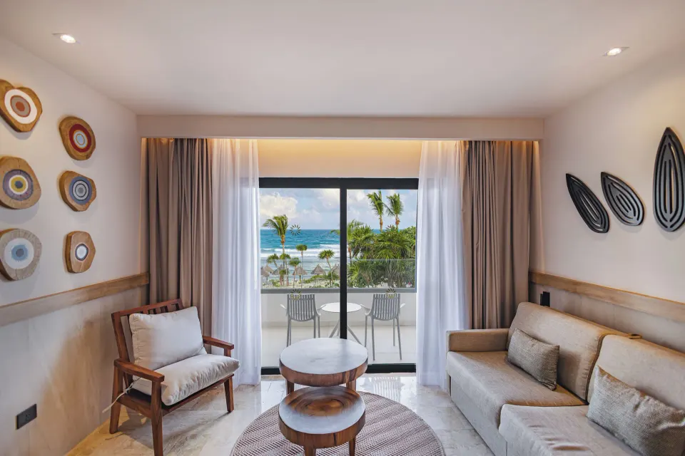 Seating area and balcony with ocean view in a Junior Suite at Bahia Principe Luxury Akumal