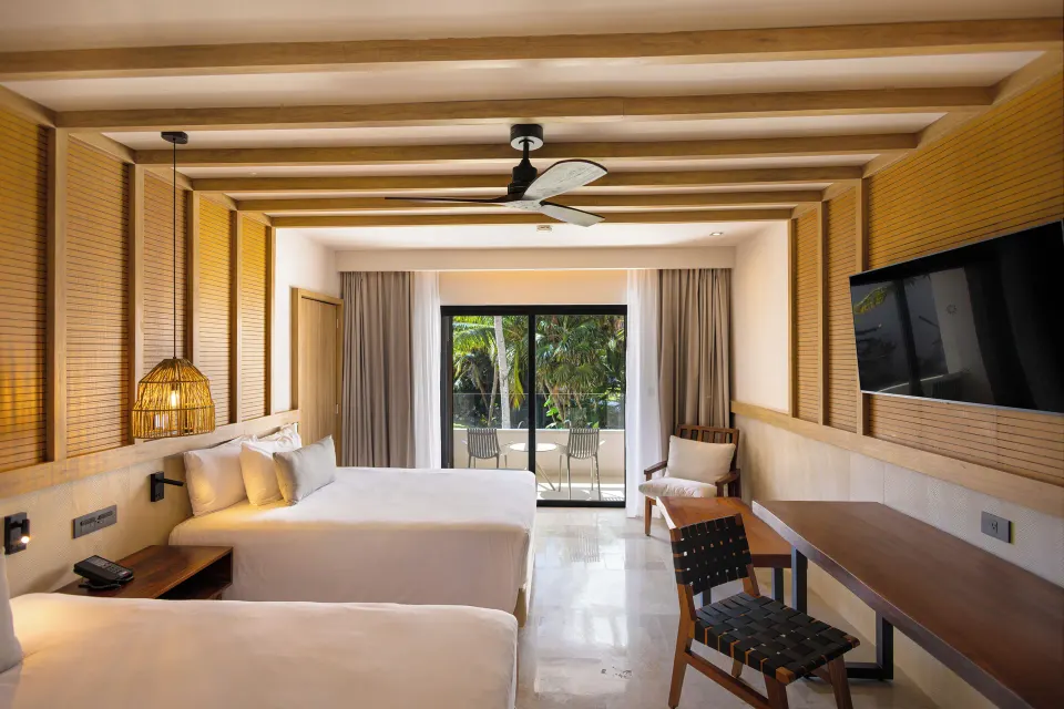 Junior Suite two-double-beds facing balcony and TV at Bahia Principe Luxury Akumal