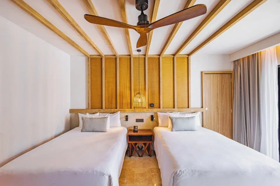 Close-up of two double beds and ceiling fan in a junior suite at Bahia Principe Luxury Akumal