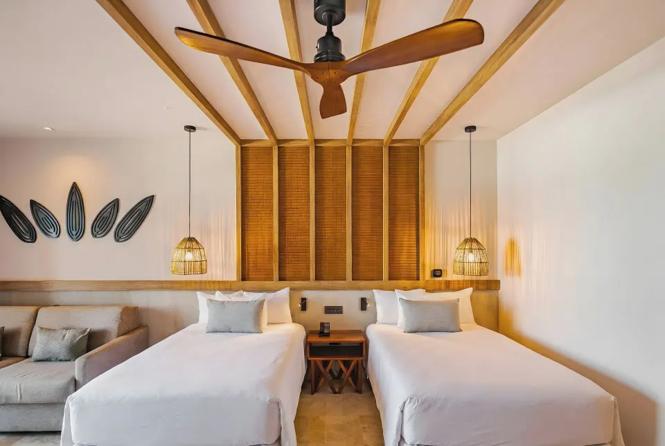 Junior Suite interior focusing on two double beds and wooden headboard at Bahia Principe Luxury Akumal