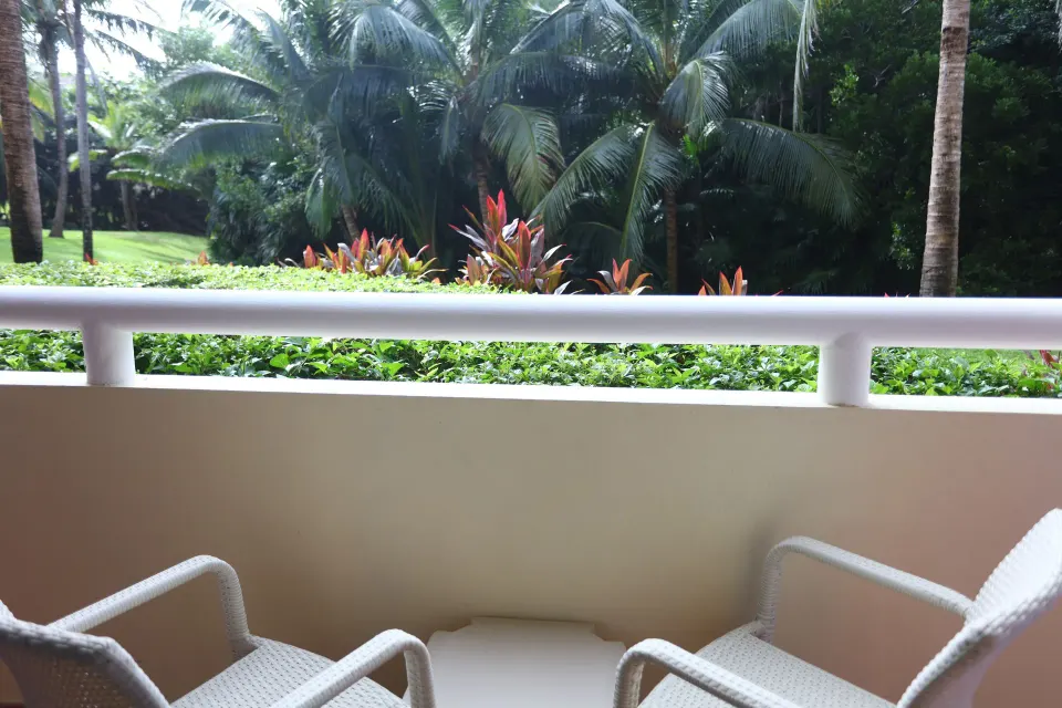 Balcony with two chairs and garden view from a Junior Suite at Bahia Principe Luxury Akumal