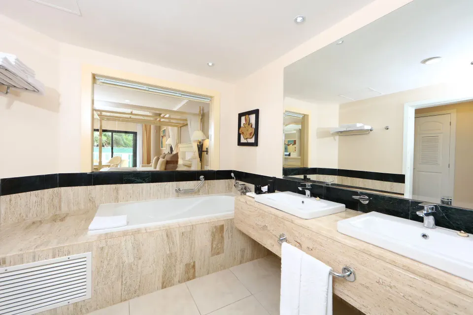 Marble bathroom with bathtub and double sinks in a Junior Suite at Bahia Principe Luxury Akumal