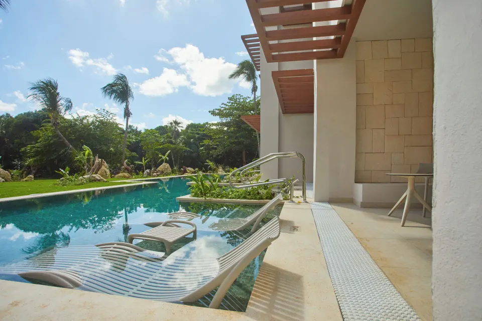 Swim-up pool edge with in-water loungers outside a Junior Suite at Bahia Principe Luxury Akumal