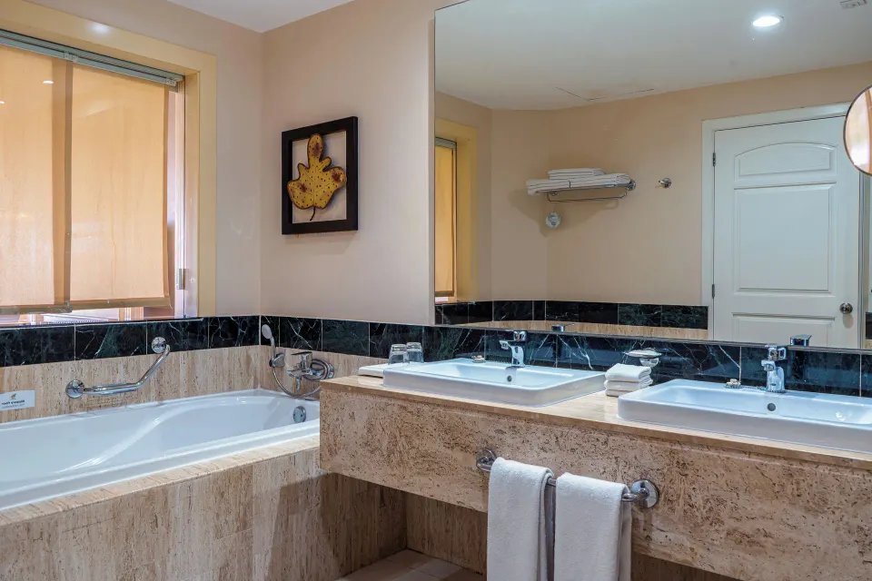 Bathroom with built-in tub and twin sinks in junior suite at Bahia Principe Luxury Akumal